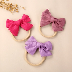 Detail view of linen baby headbands in rose and lavender on soft nylon bands