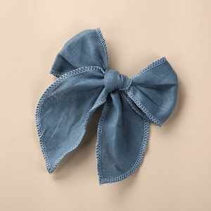 Vue macro des détails brodés d'une barrette nœud en lin de couleur bleu poudré