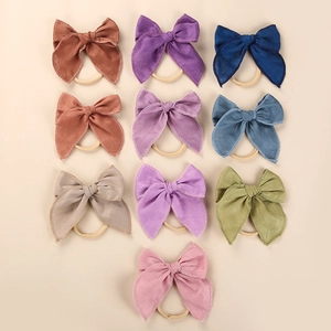 Flat lay of 10-piece baby linen bow headbands in soft Morandi colors and nylon bands