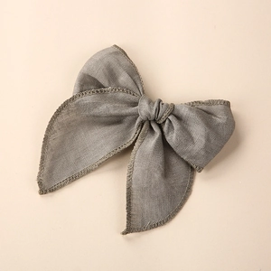 Gros plan sur le nœud en lin gris montrant la texture naturelle et les coutures de bord