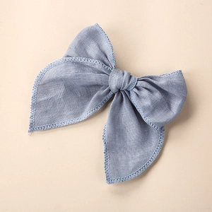 Détail d'un nœud papillon en lin bleu clair avec broderie sur les bords dentelés