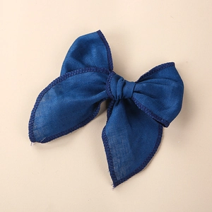 Détail de la pince à cheveux en lin bleu avec des coutures brodées sur les bordures