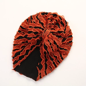 Detailaufnahme der Baby-Turbanmütze mit schwarzem Strick und orangefarbenem Faltennetz