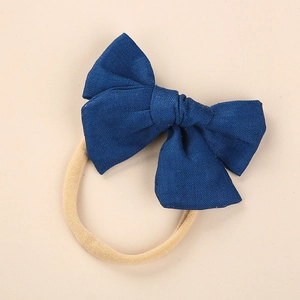 Macro shot of navy blue linen bow and soft seamless nylon headband for newborns