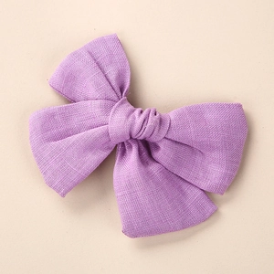 Texture détaillée du nœud en lin et coton violet pour accessoire cheveux fille