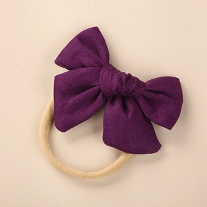 Detailed close-up of dark purple linen bow headband with soft nylon baby elastic band