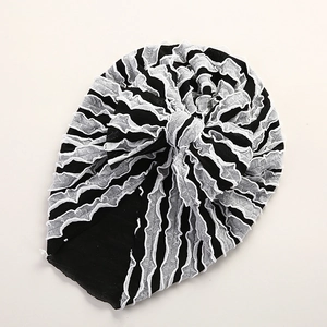 Detailaufnahme einer Baby-Turban-Mütze mit schwarz-weißen Streifen und großer Schleife