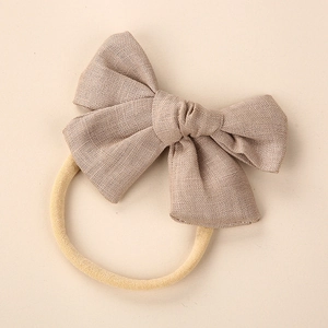 Close-up of linen bow headband with soft nylon strap for newborn baby skin