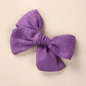 Détail du nœud papillon en lin violet foncé avec texture tissée pour les cheveux