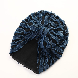 Detail der Baby-Turban-Mütze mit gestuften blauen Spitzenrüschen und schwarzem Strickstoff