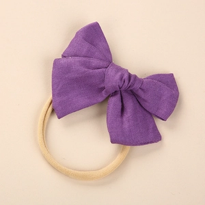 Detail view of large purple linen bow headband with soft nylon elastic for newborns