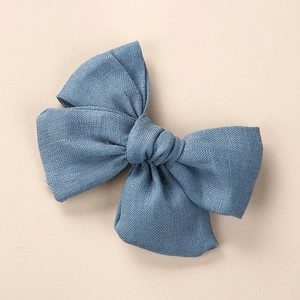 Vue détaillée de la texture du lin bleu sur la grande pince à cheveux nœud papillon
