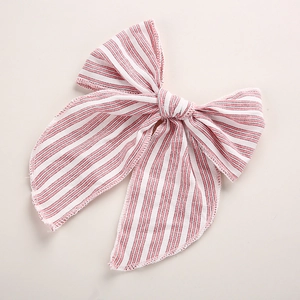 Détail du nœud de cheveux rayé rose et blanc montrant les finitions de couture