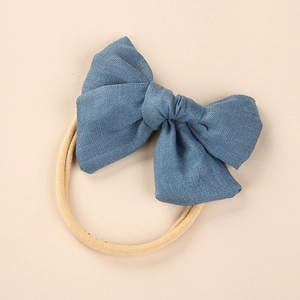 Macro shot of blue linen bow texture on soft nylon baby headband for infants