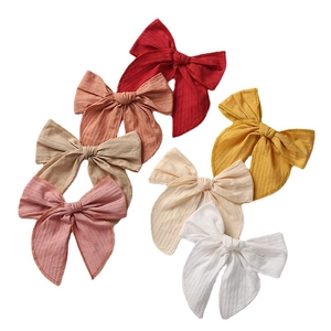 Set of 6 textured linen baby bow headbands in assorted warm colors on white background