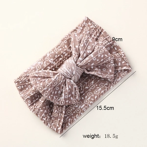 Detail view of baby bow headband in light brown with size 15.5cm and 9cm measurements