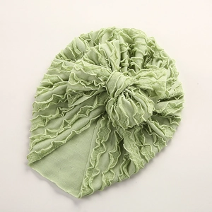 Detail von hellgrüner geraffter Baby-Turbanmütze mit großer Schleife und Rippenstoff