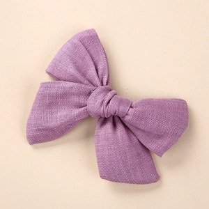 Vue détaillée de la texture du tissu d'un grand nœud à cheveux en lin violet clair