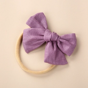 Close-up of a purple linen bow with high-elastic seamless nylon headband for baby comfort