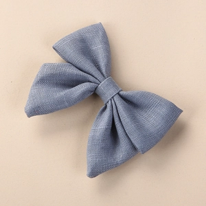 Detailed texture view of a handmade blue linen bow hair clip for young girls
