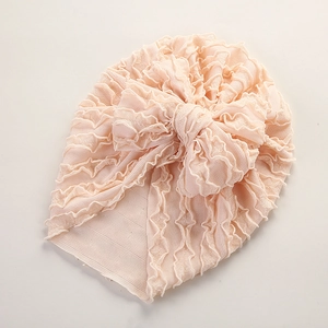 Detailaufnahme einer Baby-Turbanmütze mit geraffter Textur und rosa dekorativer Schleife