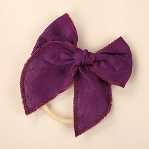 Detailed macro view of dark purple linen bow headband with exquisite embroidery edge