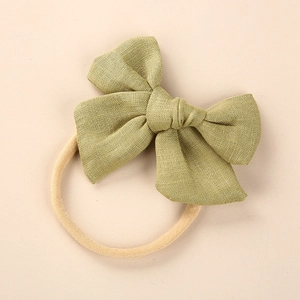 Detailed view of olive green linen bow on high-elasticity nylon headband for babies
