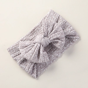 Close-up of baby headband featuring soft floral jacquard fabric and a large bow detail