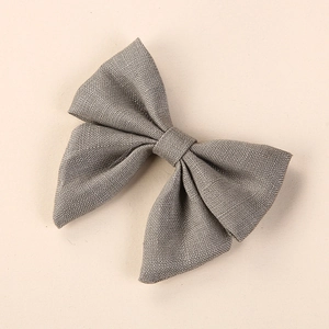 Detail of gray linen bow hair clip showing handcrafted fabric texture and knotted center
