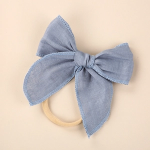 Detail of light blue linen bow baby headband with soft stretch nylon elastic band
