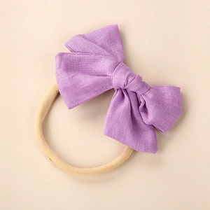 Close-up of lavender linen bow headband with soft nude nylon band for newborn babies