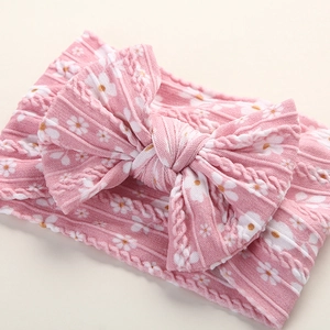 Close-up of soft pink floral nylon headband with large bow and cable knit texture