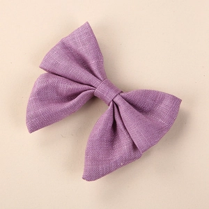 Detailed macro view of the purple linen fabric texture on a handmade girls' bow hair clip