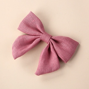 Detail shot of dusty pink linen bow hair clip showing natural fabric texture and weave