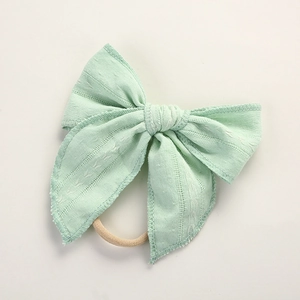 Nahaufnahme von minzgrünem Jacquard-Babystirnband mit weicher Schleife und Nylonband