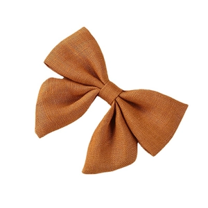 Handmade linen bow hair clip in warm ochre color for children, high quality fabric texture