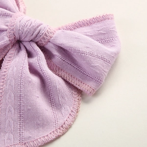 Makroaufnahme eines fliederfarbenen Jacquard-Baumwoll-Babystirnbandes mit Blattmuster-Stickerei