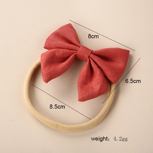 Detailed view of red linen baby bow headband showing 8cm x 6.5cm dimensions and textures