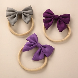 Detailed close-up of three linen baby bow headbands with soft elastic nylon bands