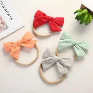 Detailed set of four elastic cotton bow headbands for infants in assorted soft colors