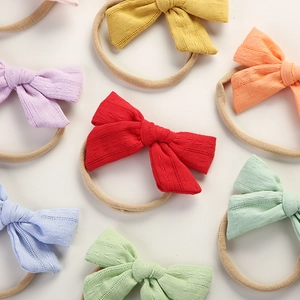 Detail showing various colorful cotton bow headbands with soft elastic nylon bands