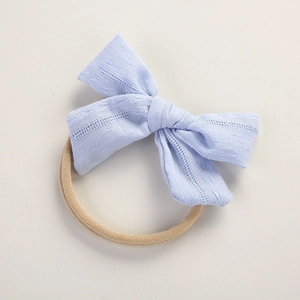 Close-up of light blue textured cotton bow on a soft elastic nylon baby headband