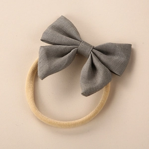 Detail of grey linen bow headband for babies with high elasticity beige nylon hair band