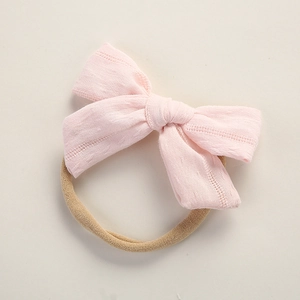 Close-up of light pink cotton bow headband with soft stretch nylon band for baby