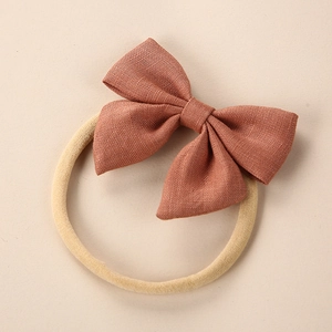 Macro detail of high-quality linen fabric texture on a vintage brick red baby bow headband