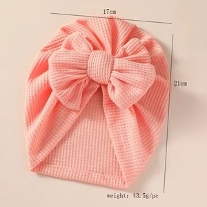 Pink waffle knit baby turban hat showing 17cm by 21cm size dimensions and weight