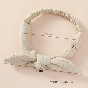 Detail view of beige cotton bunny ear headband showing pleated fabric texture and 19cm size