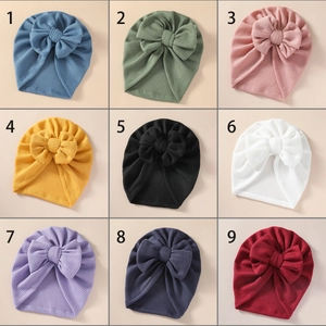 Detailed grid view showing waffle knit texture and bow decor on baby hats in nine colors