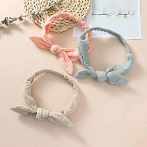 Detailed close-up of three cotton knotted headbands in pink, blue, and beige colors
