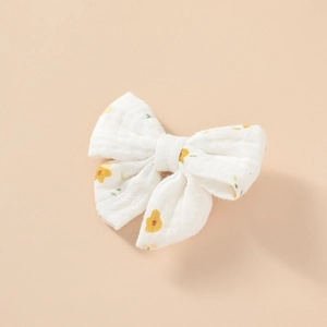 Détail de pinces à cheveux en mousseline de coton avec motifs floraux jaunes